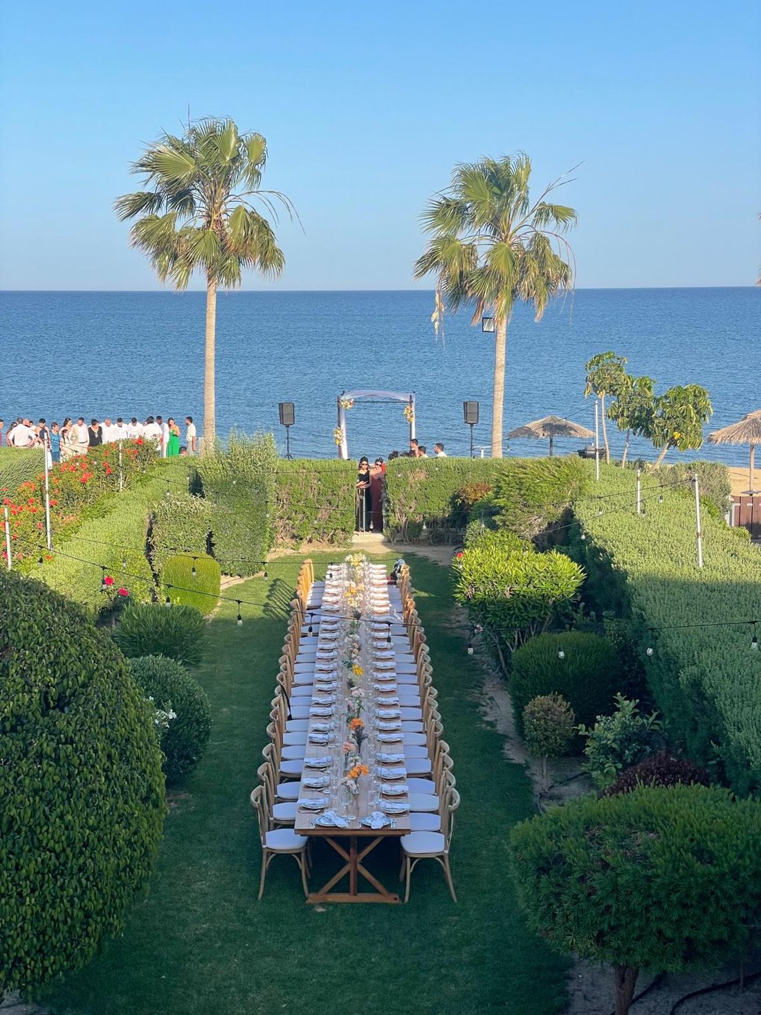 Long wedding table in a seaside garden at Atlantis Gardens, set for dinner